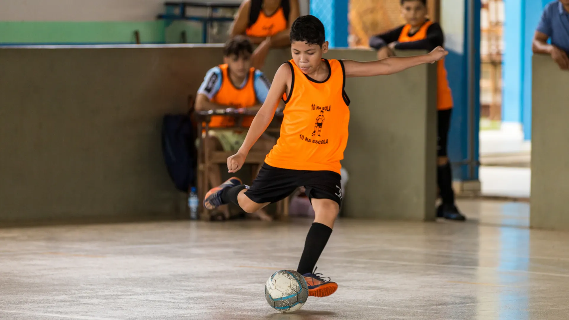Criança atendida pelo projeto 10 na Bola, 10 na Escola durante um treino de futsal
